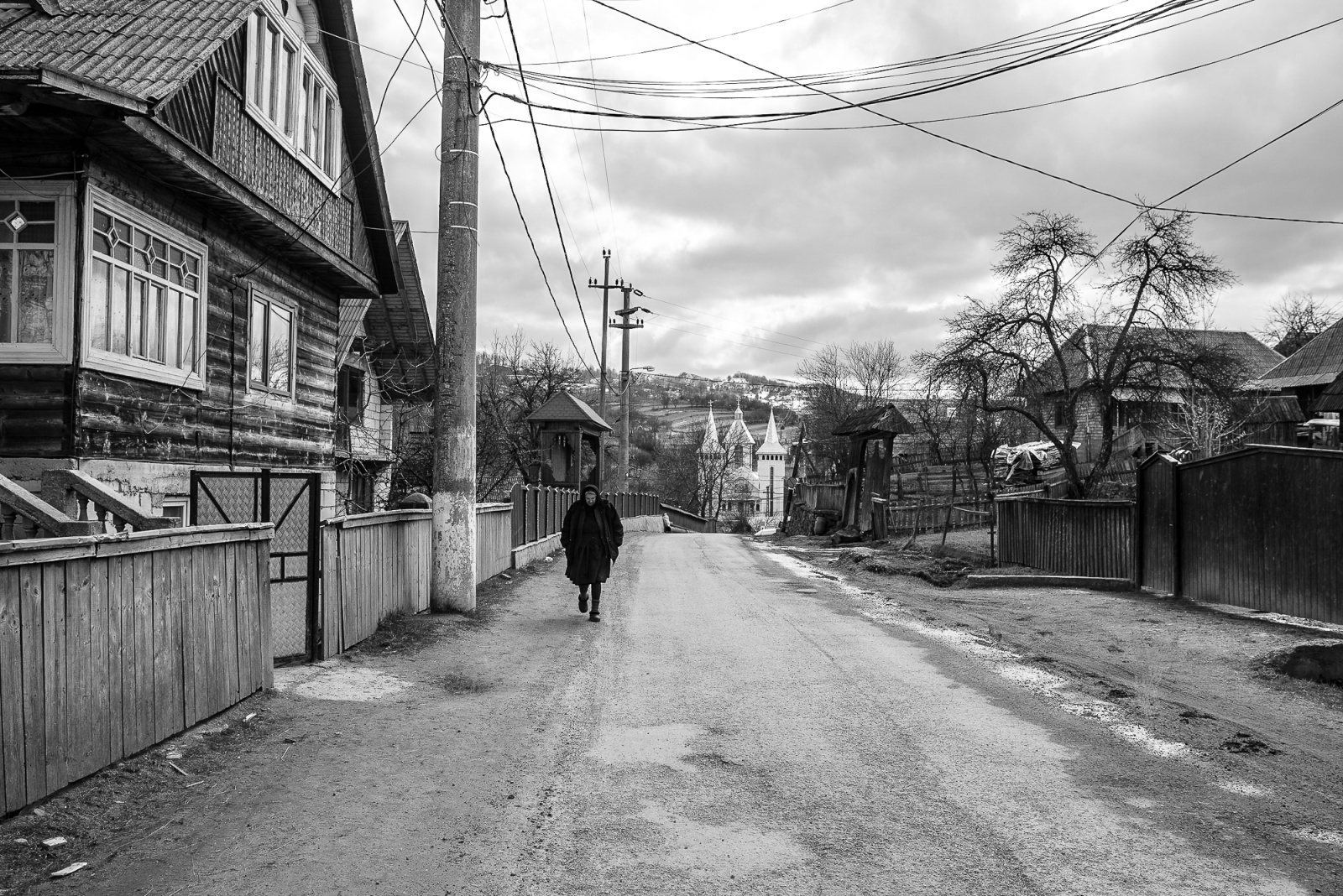 Una donna torna a casa dopo la funzione religiosa domenicale. Nonostante sia aprile il clima è rigido, e a volte nevica. Sullo sfondo la chiesa di Breb.
Breb, Maramures, Romania. Aprile 2015 
