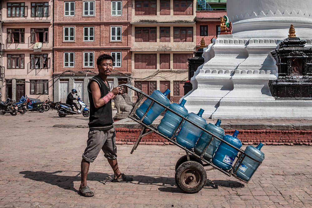 ITA
Un lavoratore addetto al trasporto dell’acqua in una piccola piazza a Kathmandu. 
ENG
A man with a water bowl in a small square in Kathmandu.